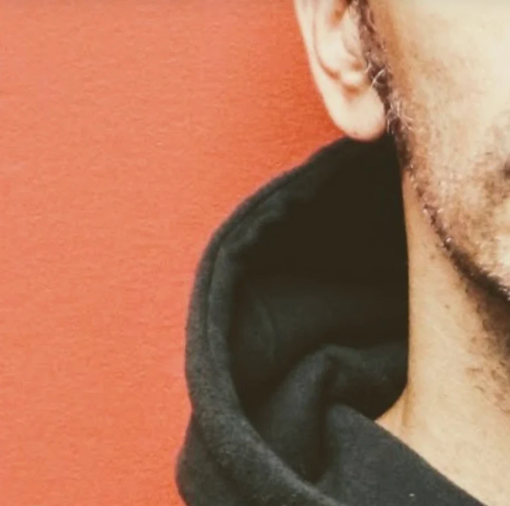 Close cropped portrait of Patrick Domanico against an orange background